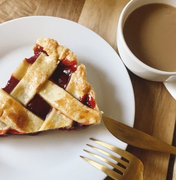 Slice of pie with silverware and coffee.