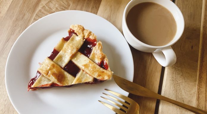 Slice of pie with silverware and coffee.