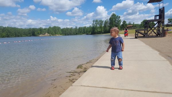 A toddler on the beach at Hawk Island Park, Lansing, Michigan