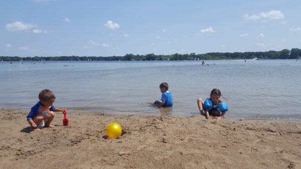 Children dig at the beach at Lake Lansing, Michigan